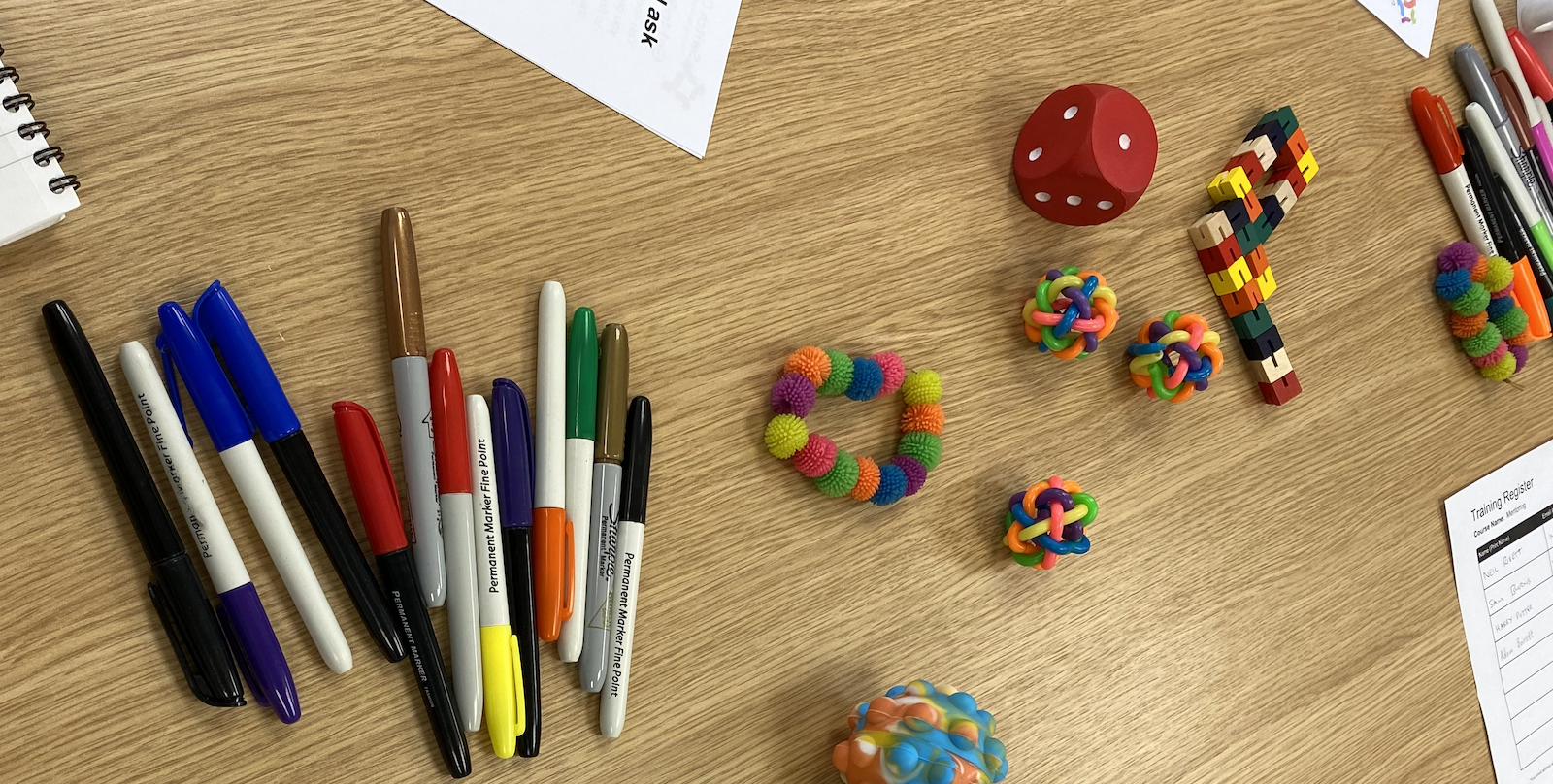 Training materials, pens and puzzles laid out on a table